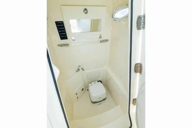 Slide: The Image of Manufacturer Provided Image: 2023 Cobia 240 Center Console boat interior with compact toilet and sink. - 19