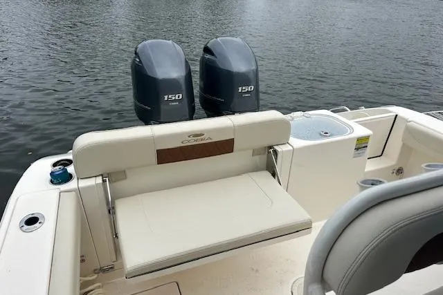 Slide: The Image of 2023 Cobia 240 Center Console boat with twin 150 engines on a calm water backdrop. - 21