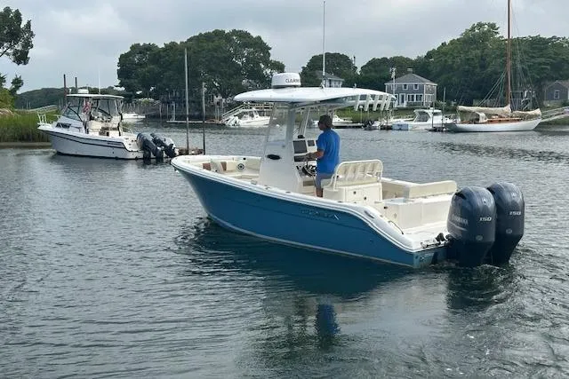Slide: The Image of 2023 Cobia 240 Center Console boat on calm water, featuring dual outboard motors. - 3