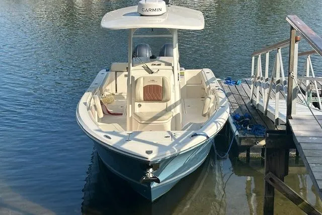 Slide: The Image of 2023 Cobia 240 Center Console boat docked on calm water. - 7