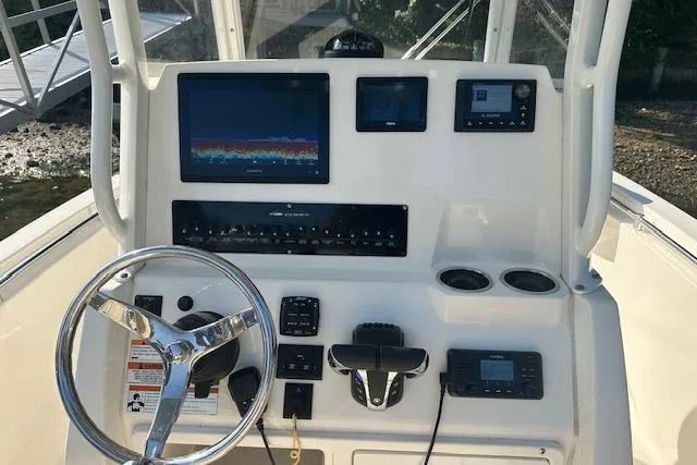 Slide: The Image of 2023 Cobia 240 Center Console dashboard with steering wheel and electronic displays. - 8