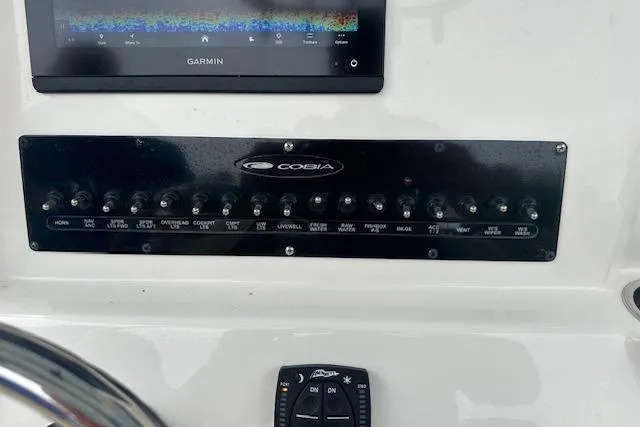Slide: The Image of 2023 Cobia 240 Center Console dashboard with Garmin display and control panel. - 9