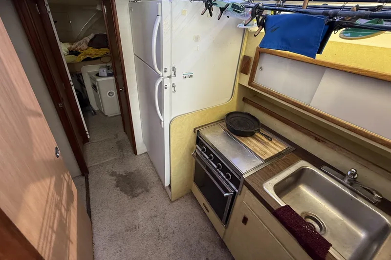 Slide: The Image of 1978 Bertram 42 Convertible boat kitchen with stove, sink, and refrigerator. - 18