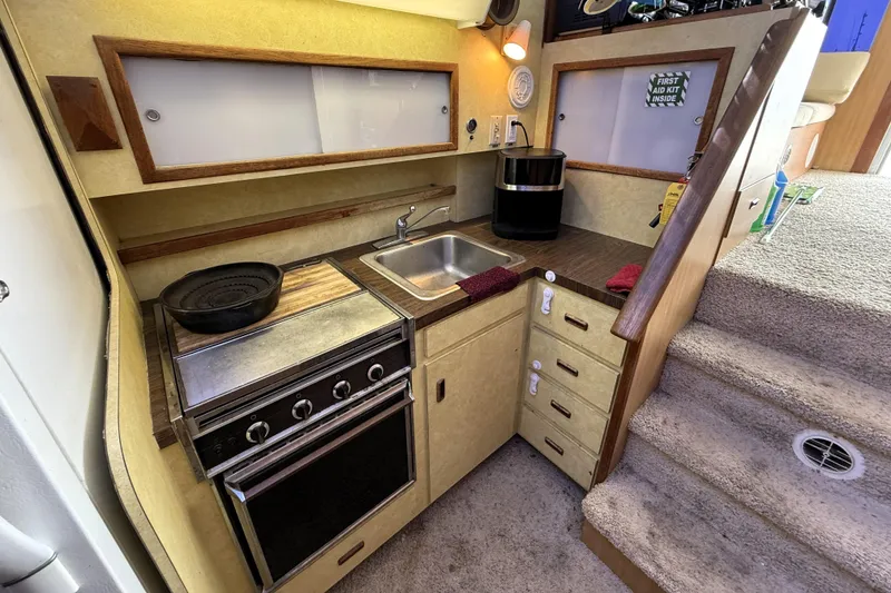 Slide: The Image of 1978 Bertram 42 Convertible yacht kitchen with stove, sink, and storage cabinets. - 19