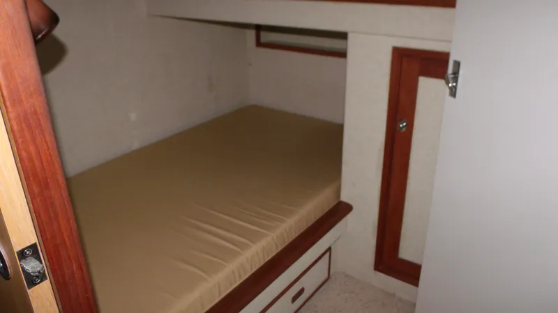 Slide: The Image of 1978 Bertram 42 Convertible cabin interior with bed and storage. - 24