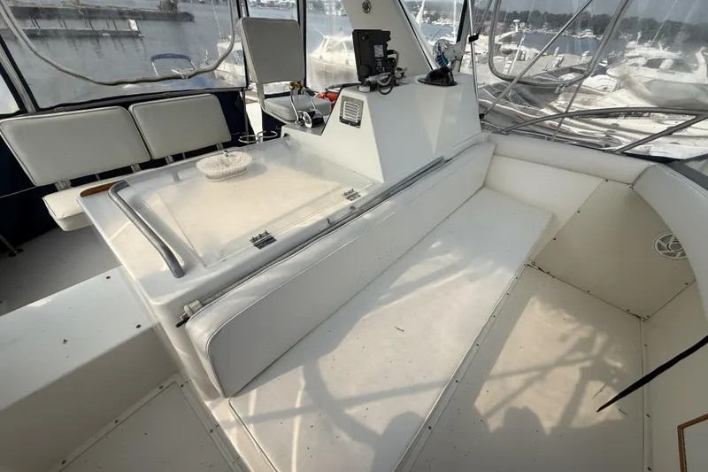 Slide: The Image of 1978 Bertram 42 Convertible boat interior with white seating and control panel. - 30