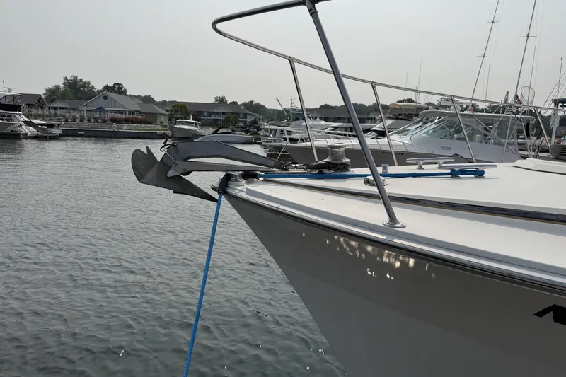 Slide: The Image of 1978 Bertram 42 Convertible yacht docked in a marina, featuring a prominent anchor. - 49