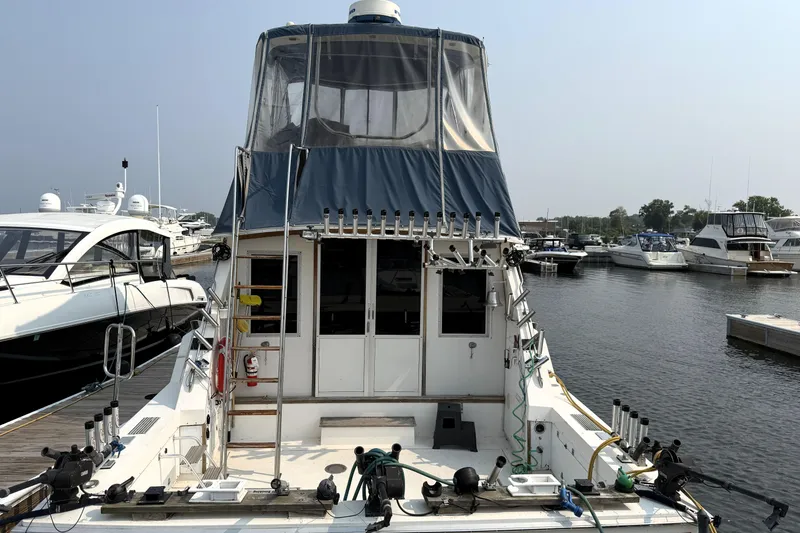 Slide: The Image of 1978 Bertram 42 Convertible yacht docked at marina, featuring fishing equipment and covered flybridge. - 6