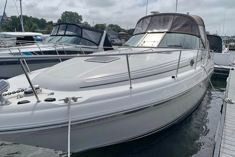 The Image of 2000 Sea Ray 340 Sundancer docked at marina, featuring sleek white design and spacious deck. - 0