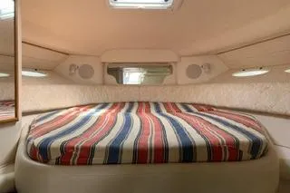 Slide: The Image of Interior cabin of Sea Ray 340 Sundancer with striped bedding and overhead lighting. - 5