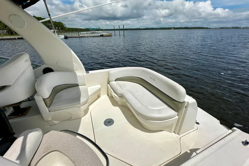 Slide: The Image of 2006 Sea Ray 260 Sundancer boat interior with seating, overlooking calm waters and cloudy sky. - 12