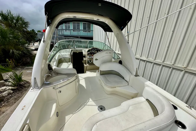 Slide: The Image of 2006 Sea Ray 260 Sundancer boat interior with white seating and dashboard. - 16