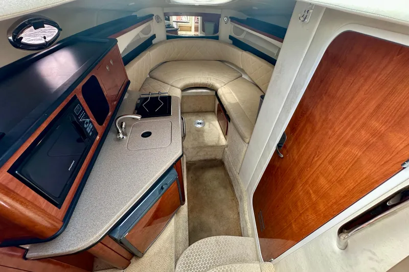 Slide: The Image of Interior of 2006 Sea Ray 260 Sundancer boat with kitchenette and seating area. - 28
