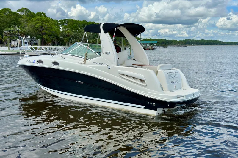 Slide: The Image of 2006 Sea Ray 260 Sundancer boat cruising on a calm lake under a cloudy sky. - 3
