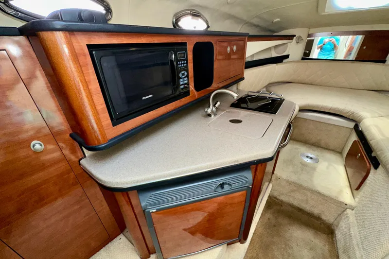 Slide: The Image of 2006 Sea Ray 260 Sundancer cabin interior with kitchenette and seating area. - 30
