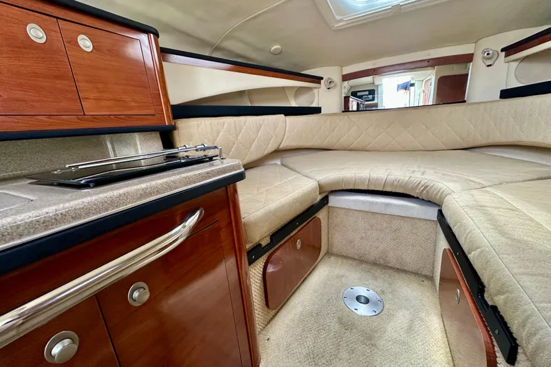 Slide: The Image of Interior of 2006 Sea Ray 260 Sundancer with cozy seating and wooden cabinetry. - 31