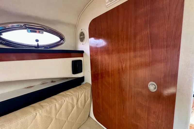 Slide: The Image of Interior cabin of 2006 Sea Ray 260 Sundancer with wood paneling and porthole window. - 37