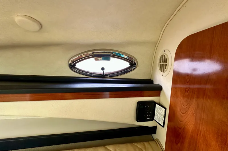 Slide: The Image of Interior cabin view of a 2006 Sea Ray 260 Sundancer boat with porthole and wood paneling. - 38