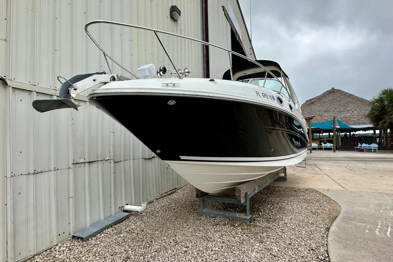 Slide: The Image of 2006 Sea Ray 260 Sundancer boat on dry dock near a marina building. - 4