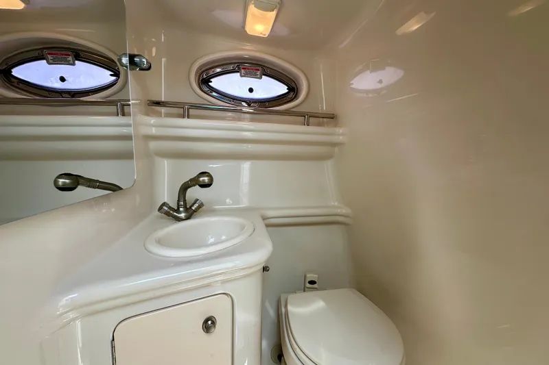 Slide: The Image of 2006 Sea Ray 260 Sundancer bathroom with sink, toilet, and porthole window. - 42