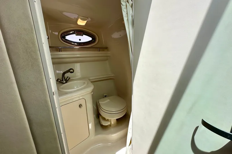 Slide: The Image of 2006 Sea Ray 260 Sundancer bathroom with sink, toilet, and porthole window. - 43