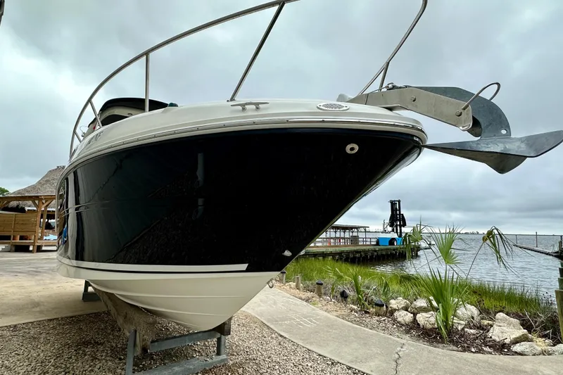 Slide: The Image of 2006 Sea Ray 260 Sundancer boat docked near a scenic waterfront. - 5