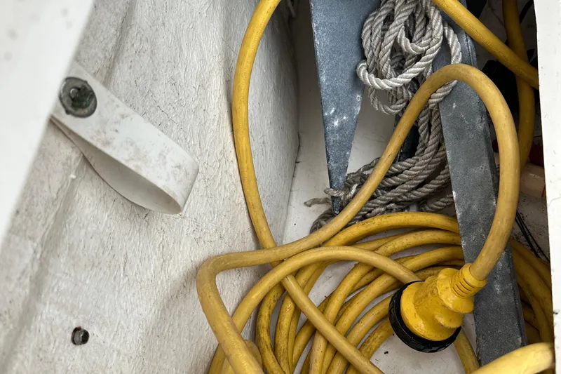 Slide: The Image of Storage compartment of 2006 Sea Ray 260 Sundancer with rope, anchor, and yellow cable. - 58