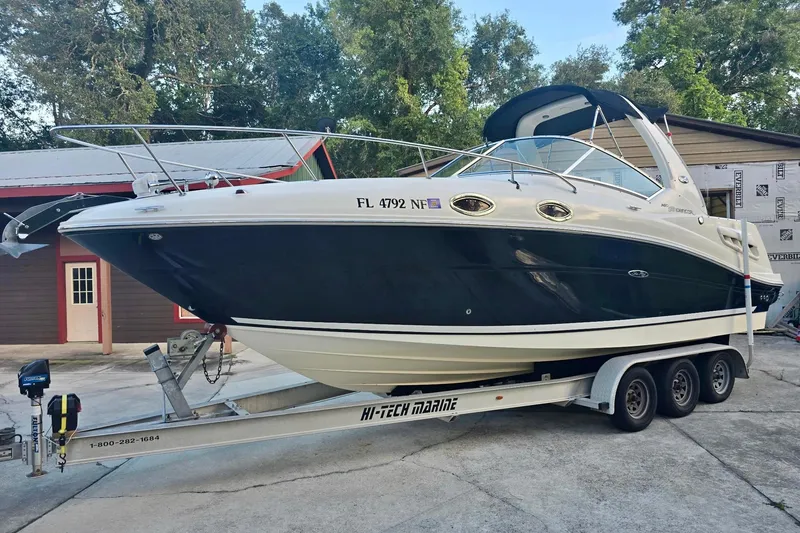 Slide: The Image of 2006 Sea Ray 260 Sundancer boat on trailer, parked outdoors near buildings. - 63