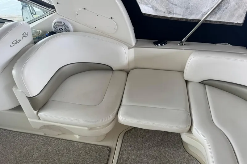 Slide: The Image of 2007 Sea Ray 260 Sundancer interior with white leather seating and carpeted flooring. - 14