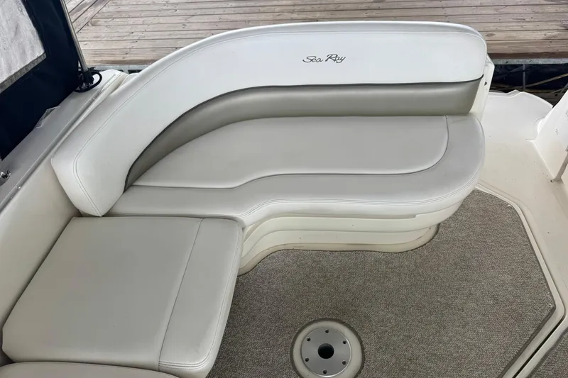 Slide: The Image of 2007 Sea Ray 260 Sundancer boat seating area with white upholstery and carpeted floor. - 15