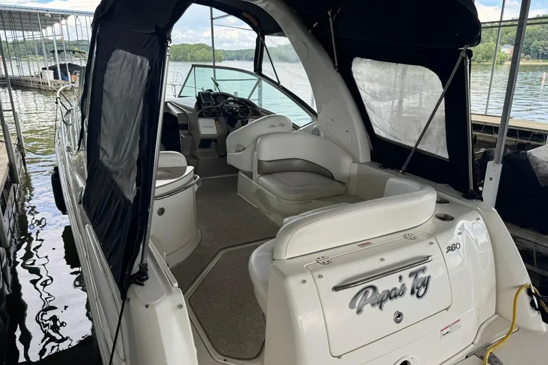 Slide: The Image of 2007 Sea Ray 260 Sundancer boat docked, featuring spacious seating and covered cockpit. - 2
