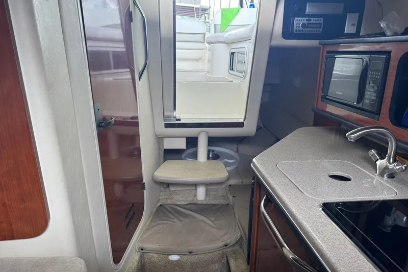 Slide: The Image of Interior of a 2007 Sea Ray 260 Sundancer boat with kitchenette and seating area. - 22