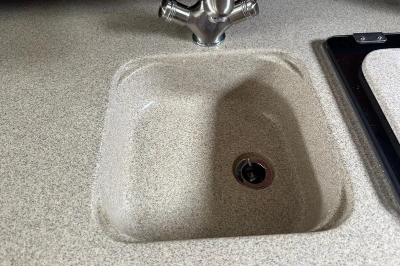 Slide: The Image of 2007 Sea Ray 260 Sundancer kitchen sink with chrome faucet and beige countertop. - 27