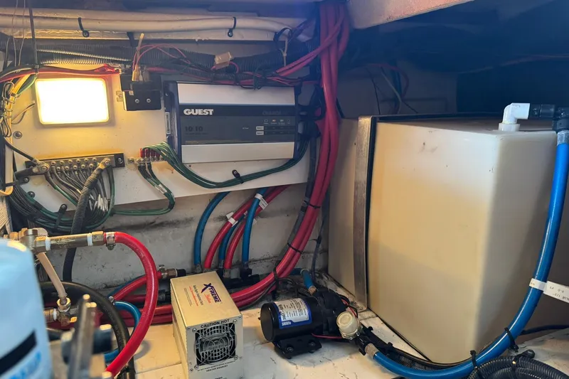 Slide: The Image of 2007 Sea Ray 260 Sundancer engine compartment with wiring, battery charger, and water tank. - 36