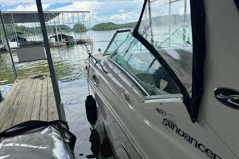 Slide: The Image of 2007 Sea Ray 260 Sundancer docked at a marina with scenic lake view. - 4