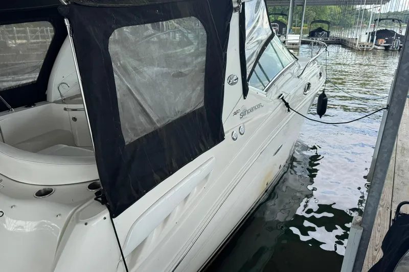 Slide: The Image of 2007 Sea Ray 260 Sundancer docked, featuring a black canopy and sleek white exterior. - 6