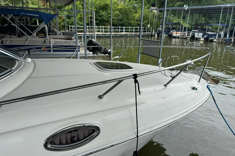 Slide: The Image of 2007 Sea Ray 260 Sundancer docked at marina, featuring sleek white deck and railing. - 7