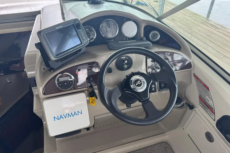 Slide: The Image of 2007 Sea Ray 260 Sundancer helm with Navman GPS and steering wheel. - 8