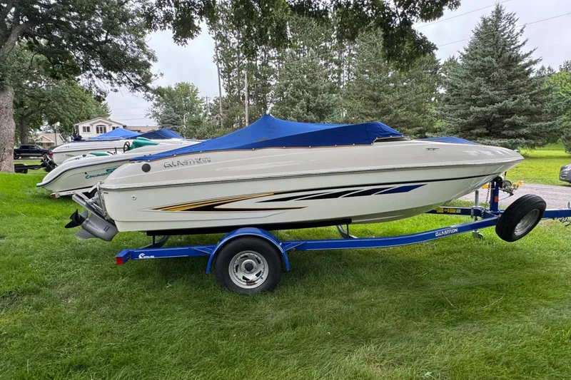 Slide: The Image of 2008 Glastron MX175 boat on trailer, parked on grass with trees in background. - 14