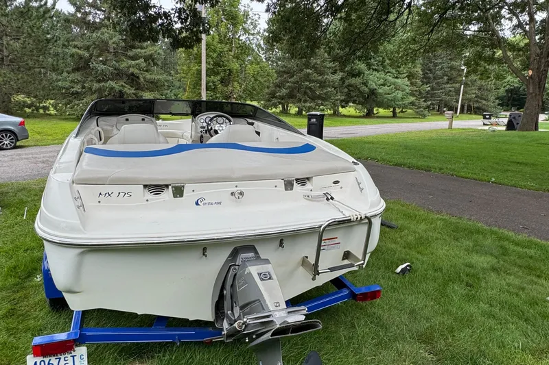 Slide: The Image of 2008 Glastron MX175 boat on trailer, parked on grass, surrounded by trees. - 3