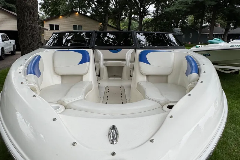 Slide: The Image of 2008 Glastron MX175 boat with white and blue interior, parked on grass. - 9