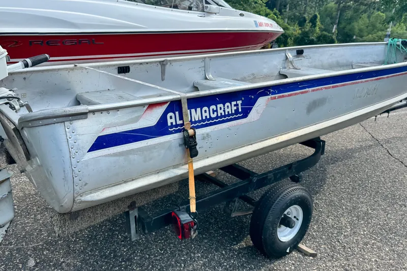 Slide: The Image of 1990 Alumacraft 145 FISHERMAN boat on trailer, parked outdoors. - 3