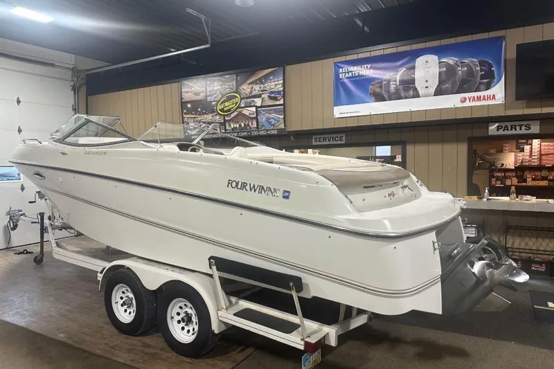 Slide: The Image of 1998 Four Winns 240 Horizon boat on trailer in indoor showroom. - 11