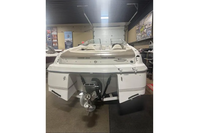 Slide: The Image of 1998 Four Winns 240 Horizon boat displayed indoors, rear view showing propeller and seating. - 12