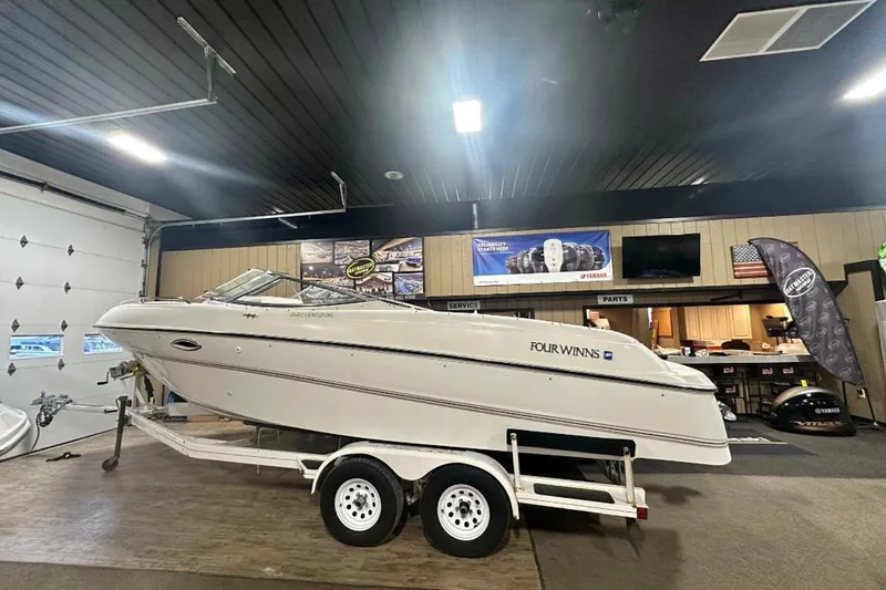 Slide: The Image of 1998 Four Winns 240 Horizon boat on trailer in showroom setting. - 13