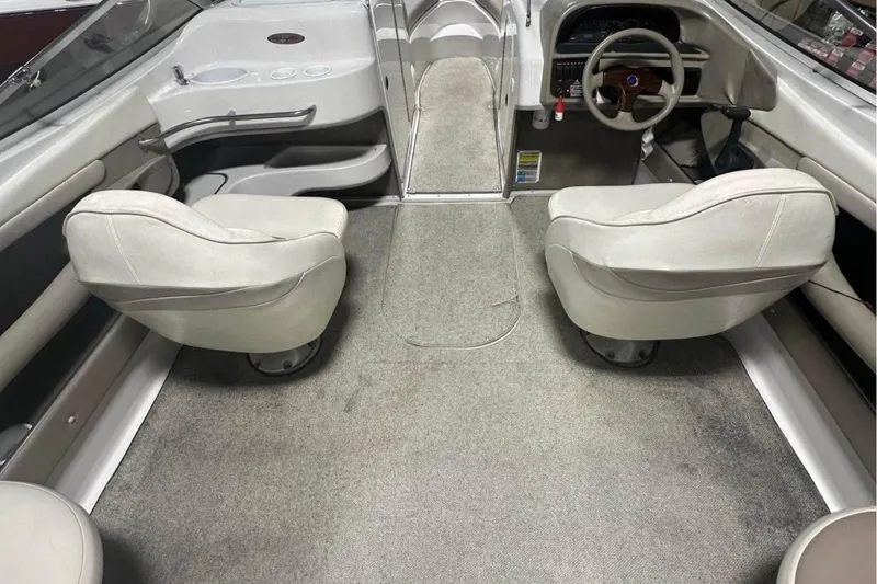 Slide: The Image of Interior of a 1998 Four Winns 240 Horizon boat, featuring seating and steering area. - 14