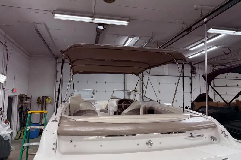 Slide: The Image of 1998 Four Winns 240 Horizon boat with canopy in a garage setting. - 21