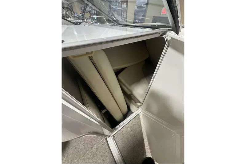 Slide: The Image of 1998 Four Winns 240 Horizon boat interior storage compartment with cushions. - 24