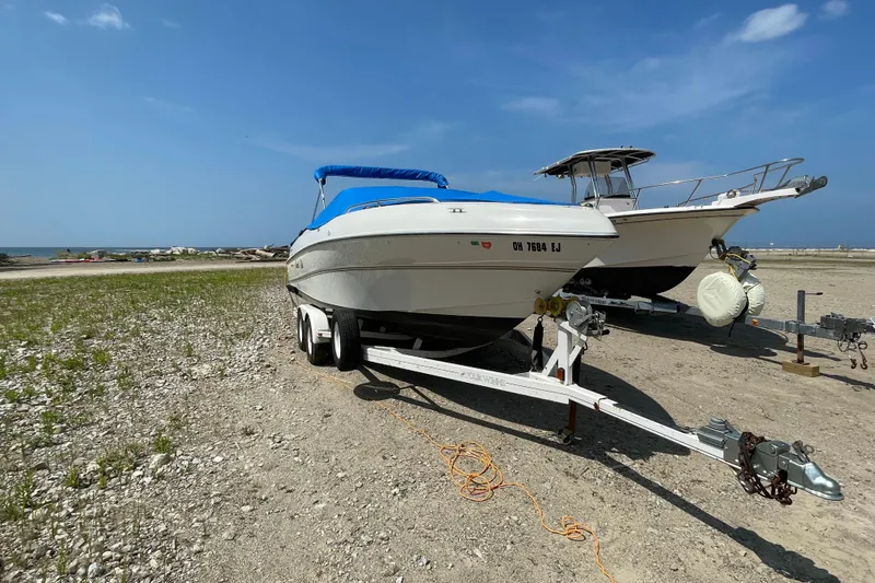 Slide: The Image of Four Winns boat on trailer by the beach under a clear blue sky. - 4