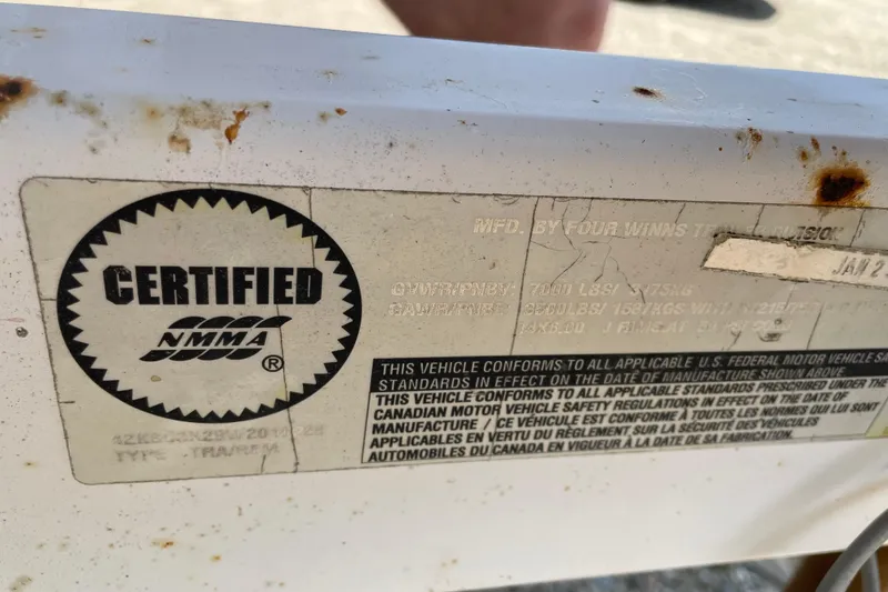 Slide: The Image of NMMA certified label on a Four Winns boat with rust spots. - 9